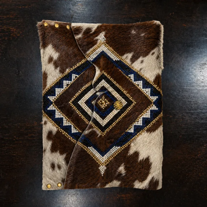 Isibane — Nguni hide sleeve with a hand-beaded blue and gold diamond medallion